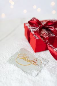 Kaboompics - Red Gift Box, Gold Thank You Card and Festive Bokeh on Snowy Fabric