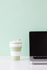 Kaboompics - Green Reusable Mug with Laptop and Vertical Copy Space on Mint Background