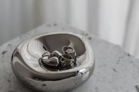 Kaboompics - Silver Bowl with Chrome Jewelry on Arabescato Marble