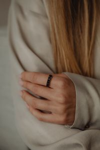 Kaboompics - Woman's Hand Wearing Gold Ring Against Tan Silk Shirt