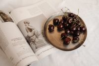 Kaboompics - Dark Cherries on a Wooden Plate with Open Book