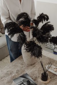 Kaboompics - Woman Arranging Black Dried Pampas Grass in a Textured Vase