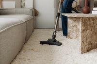 Kaboompics - Vacuum Cleaner Head Between Sofa and Coffee Table