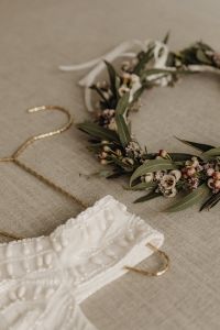 Kaboompics - Bridal Dress with Floral Hair Garland and Gold Chain on Neutral Fabric