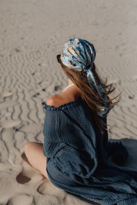 Kaboompics - Woman Sitting on Sand in Blue Off Shoulder Dress and Headscarf