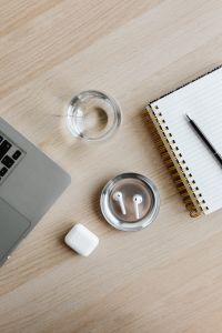 Kaboompics - Close-Up Top View of Laptop, Water Glass, AirPods and Notebook