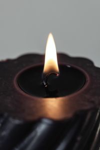 Kaboompics - Macro Black Candle Flame on Textured Wick, Warm Amber Candle Detail