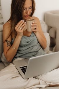 Kaboompics - Woman Enjoying Coffee Beside a Laptop on the Sofa