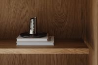 Kaboompics - Metal vase on stacked books in wooden shelf