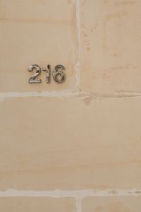 Kaboompics - House Number 216 on a Limestone Wall