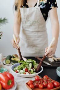 Kaboompics - Close-Up of Hands Mixing a Fresh Salad with Wooden Servers