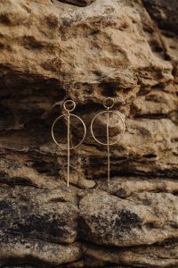 Kaboompics - Long Gold Geometric Earrings Against Layered Rock