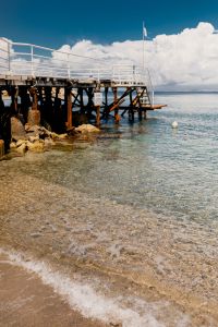 Kaboompics - Vertical Wooden Pier on Rocky Shore with White Railings and Sea View