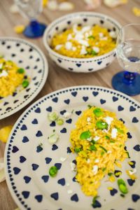 Kaboompics - Yellow rice with greens on a cute plate with blue hearts and a table decorated with flower petals