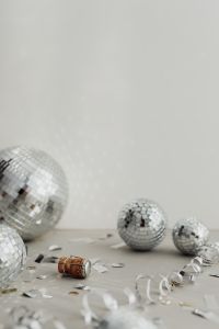 Kaboompics - New Year's Eve Still Life with Champagne Cork, Mirror Balls and Silver Confetti