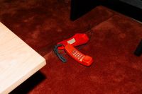 Kaboompics - Vintage Red Landline Telephone on Dark Red Carpet with Direct Flash, Retro Living Room Interior Detail