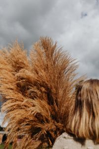 Kaboompics - Woman Holding Pampas Grass beneath a Cloudy Sky