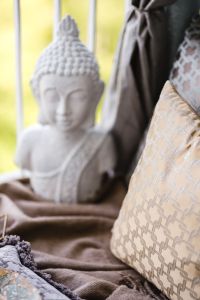 Kaboompics - White Buddha Statue and Patterned Cushion in a Sunlit Balcony Nook