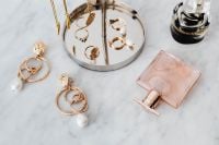 Kaboompics - Overhead Jewelry and Perfume Flat Lay on White Marble with Gold Earrings