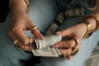 Kaboompics - Hands Rolling Dollar Bills Growth Manifestation