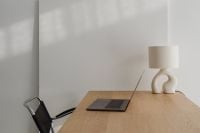 Kaboompics - Laptop On Wooden Desk Beside Sculptural Ceramic Lamp