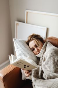 Kaboompics - Stay-at-Home Reading: Woman Curled Up Under a Blanket