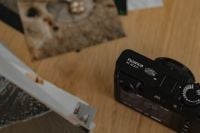 Kaboompics - Close-Up Fujifilm X100VI Camera with Printed Photos