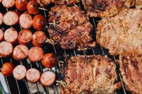 Kaboompics - Mixed Grilled Pork Neck and Sliced Sausages on a Black Barbecue Grate