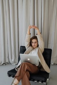 Kaboompics - Seated Businesswoman Stretching with Laptop on Her Lap