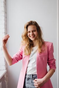 Kaboompics - Blonde Woman Raising a Hand in a Pink Blazer for Modern Fashion Content