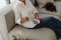 Kaboompics - Woman Eating Dessert on a Neutral Sofa with a Small Dog