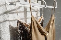 Kaboompics - Gold Satin Dress and Black Sequin Outfit on Clothing Rack
