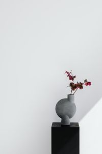 Kaboompics - Gray Sculptural Vase with Burgundy Hellebores and Copy Space