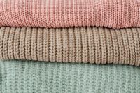 Kaboompics - Folded Pastel Sweaters on a White Shelf