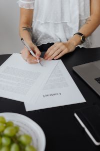 Kaboompics - Entrepreneur Reviewing Contract While Signing at Office Desk