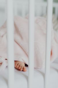 Kaboompics - Newborn Baby's Foot Peeking from a Soft Blanket in Crib