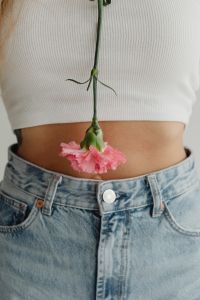Kaboompics - Vertical Floral Fashion Portrait with Purple Flower Stem over White Top and Jeans