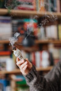 Kaboompics - Abstract Curling Smoke on a Colorful Bookshelf Background for Spiritual Wellness
