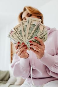 Kaboompics - Woman Hiding Her Face Behind a Fan of Dollar Bills
