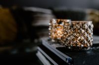 Kaboompics - Close-Up of Textured Gold Candle Cups on Dark Books