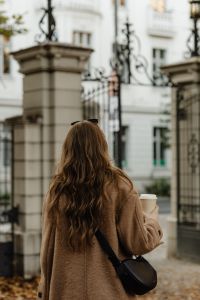 Kaboompics - Rear View of Woman Carrying Coffee at an Ornate City Gate
