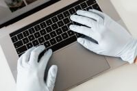 Kaboompics - Overhead View of Protective Gloved Hands Typing on Laptop