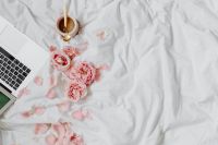 Kaboompics - Home Office Flat Lay with Laptop, Pink Roses and Coffee on White Bedding, Wide Copy Space
