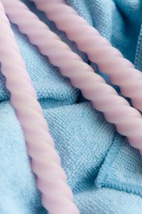 Kaboompics - Pastel Pink Twisted Candles on Blue Knit Fabric, Soft Decorative Still Life Background