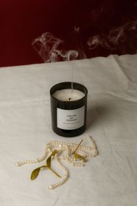 Kaboompics - Extinguished Black Candle with Smoke, Pearls and Burgundy Backdrop