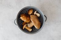 Kaboompics - Mixed Wild Mushrooms in a Black Colander From Above