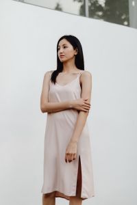 Kaboompics - Woman in Pale Slip Dress with Arms Crossed in Minimalist Outdoor Portrait