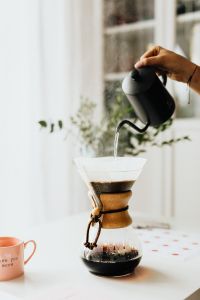 Kaboompics - Hand Pouring Hot Water into Chemex Coffee Maker with Copy Space