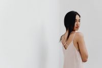 Kaboompics - Woman in Pale Slip Dress against White Wall with Copy Space