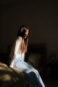 Kaboompics - Woman Sitting on Bed in Soft Morning Light